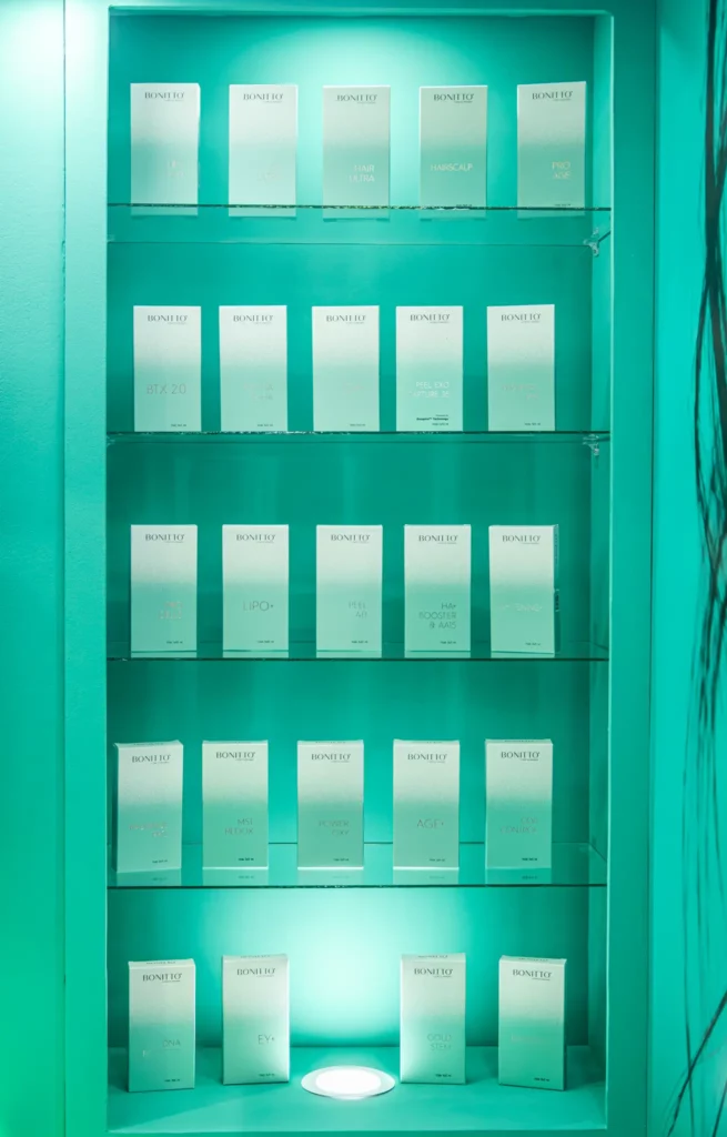 صندوق عرض مزود بأربعة أرفف زجاجية، يحمل كل منها عدة لوحات زجاجية بلورية أو لوحات جوائز، وكلها مرتبة بعناية على خلفية مضاءة باللون الأزرق المخضر.