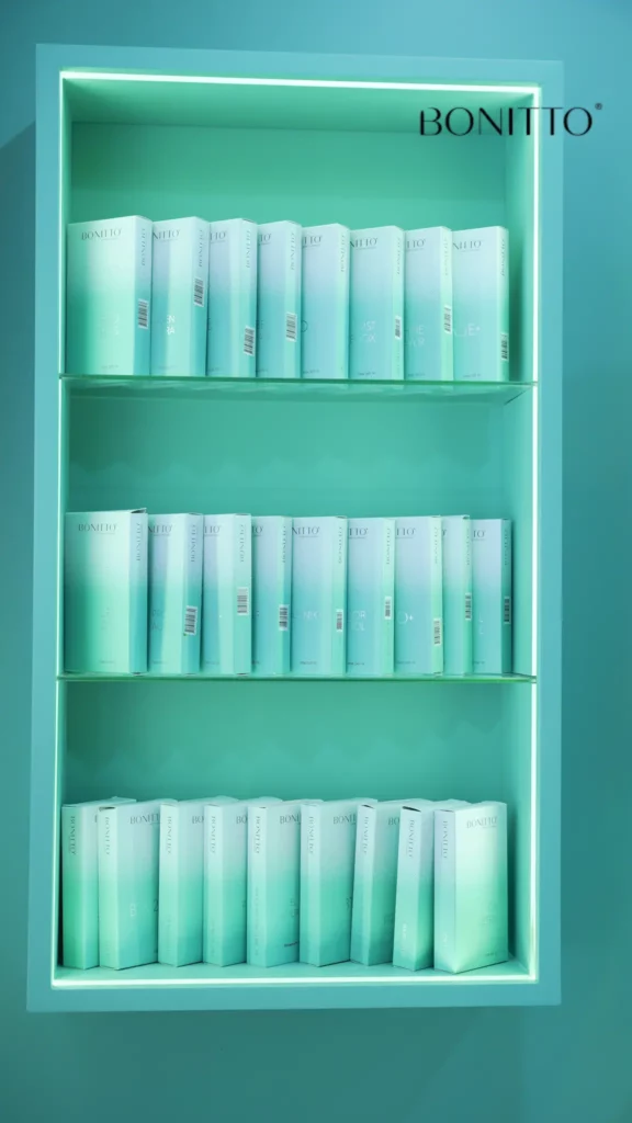 A turquoise display shelf holds neatly arranged turquoise gradient boxes. The word "BONITTO" is printed in black in the top right corner against the turquoise background.